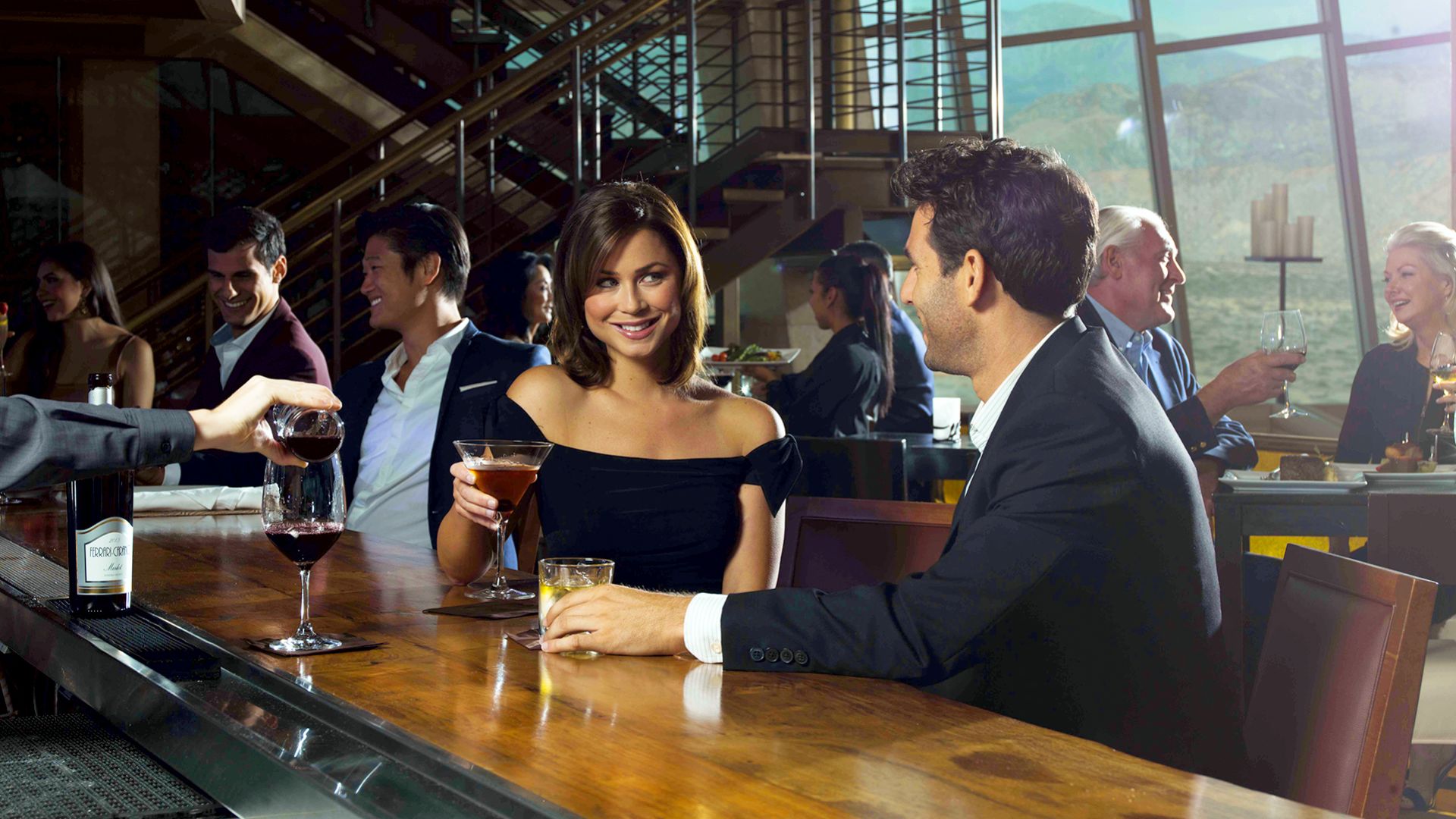 A Man And Woman Sitting At A Bar With Drinks